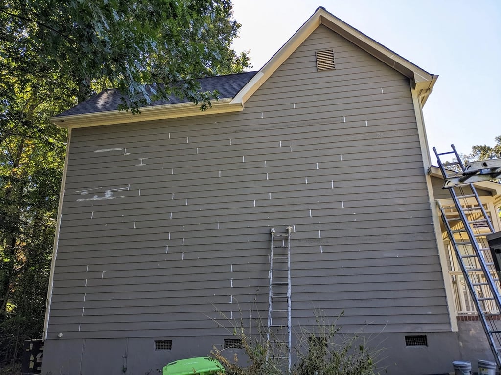 Image of the left side of a house in Raleigh, NC that has been caulked and sealed before painting.
