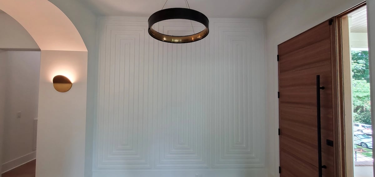 Intricate white foyer wall trim on Wynneford Way in the Devon neighborhood of Raleigh, NC, professionally caulked and finished by A Touch of Color Painting to ensure seamless architectural joints.
