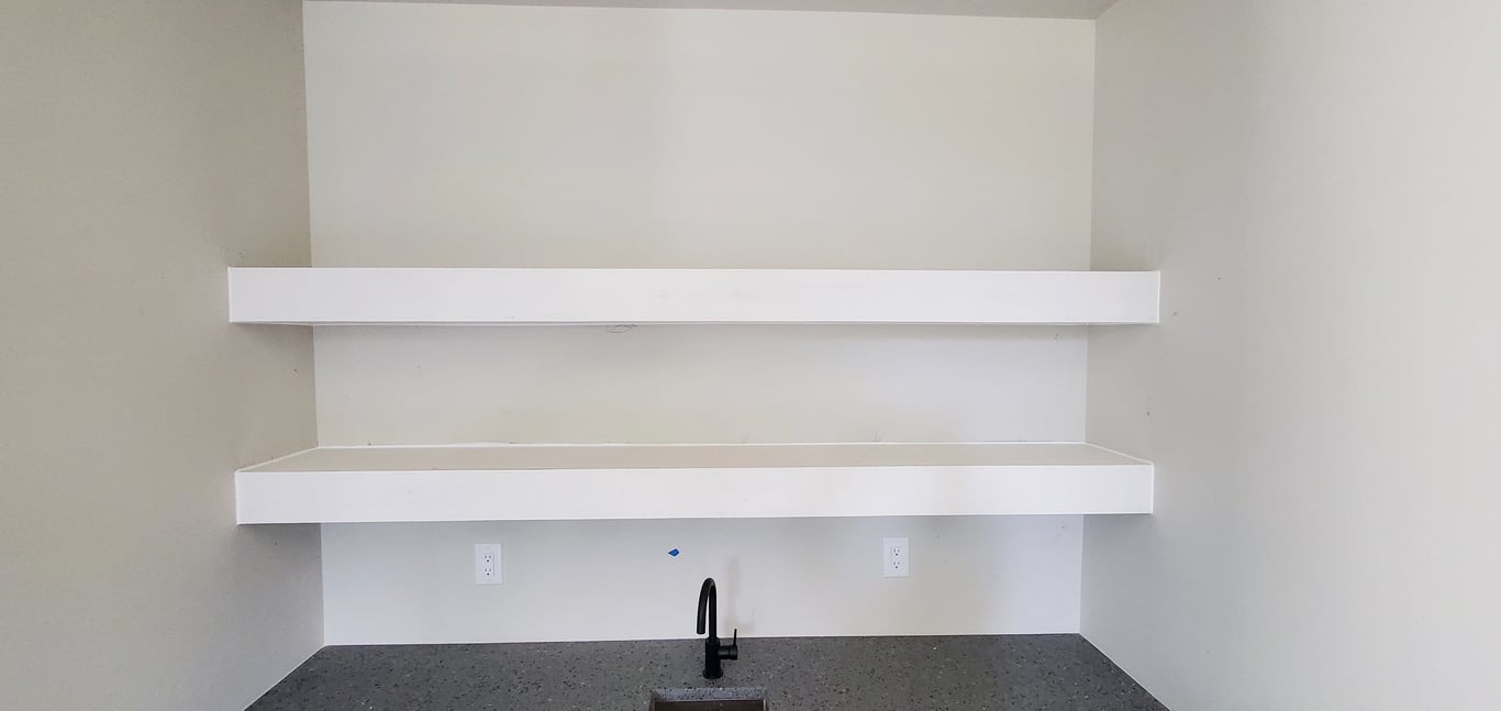 A newly installed floating shelf that has been primed and the nails filled with Crawford's putty.