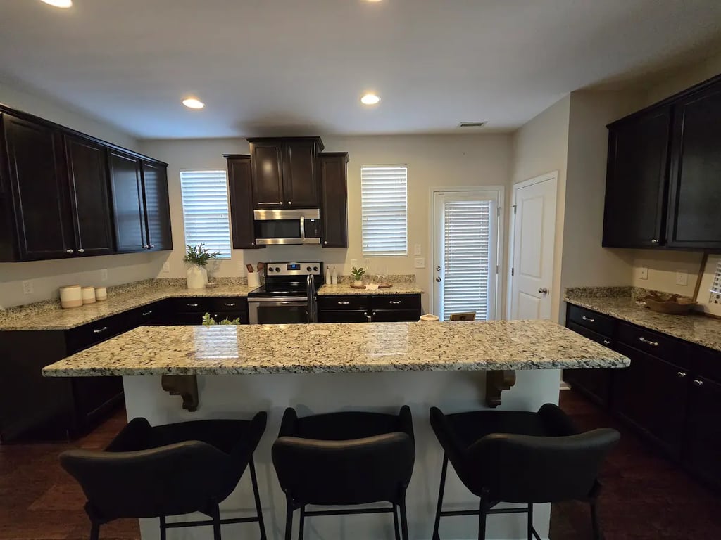 Custom black-stained kitchen cabinets in Durham, NC, by A Touch of Color Painting & General Contracting, featuring a durable, translucent finish that preserves natural wood grain in the 27713 area.
