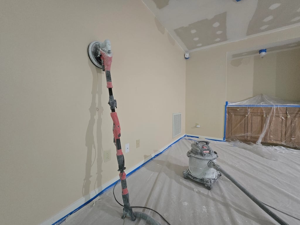 Power sanding interior drywall before painting after drywall repairs to reduce dust and for more thorough sanding.