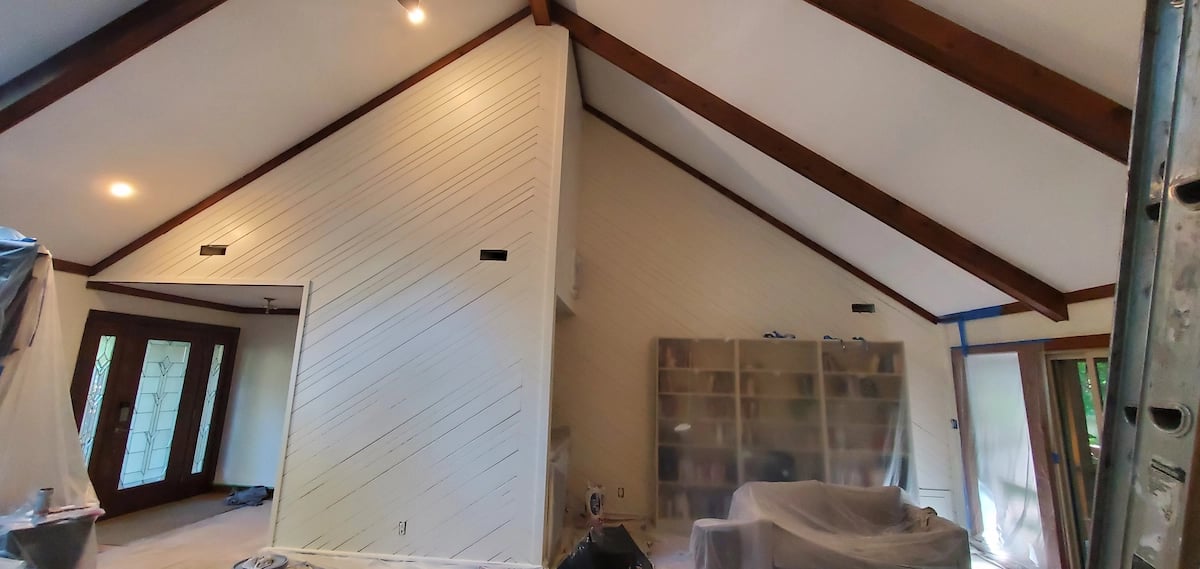 A professional trim transition project in the Stone Bridge neighborhood of Raleigh, NC, featuring dark wood trim primed with Zinsser and painted white with full furniture protection.