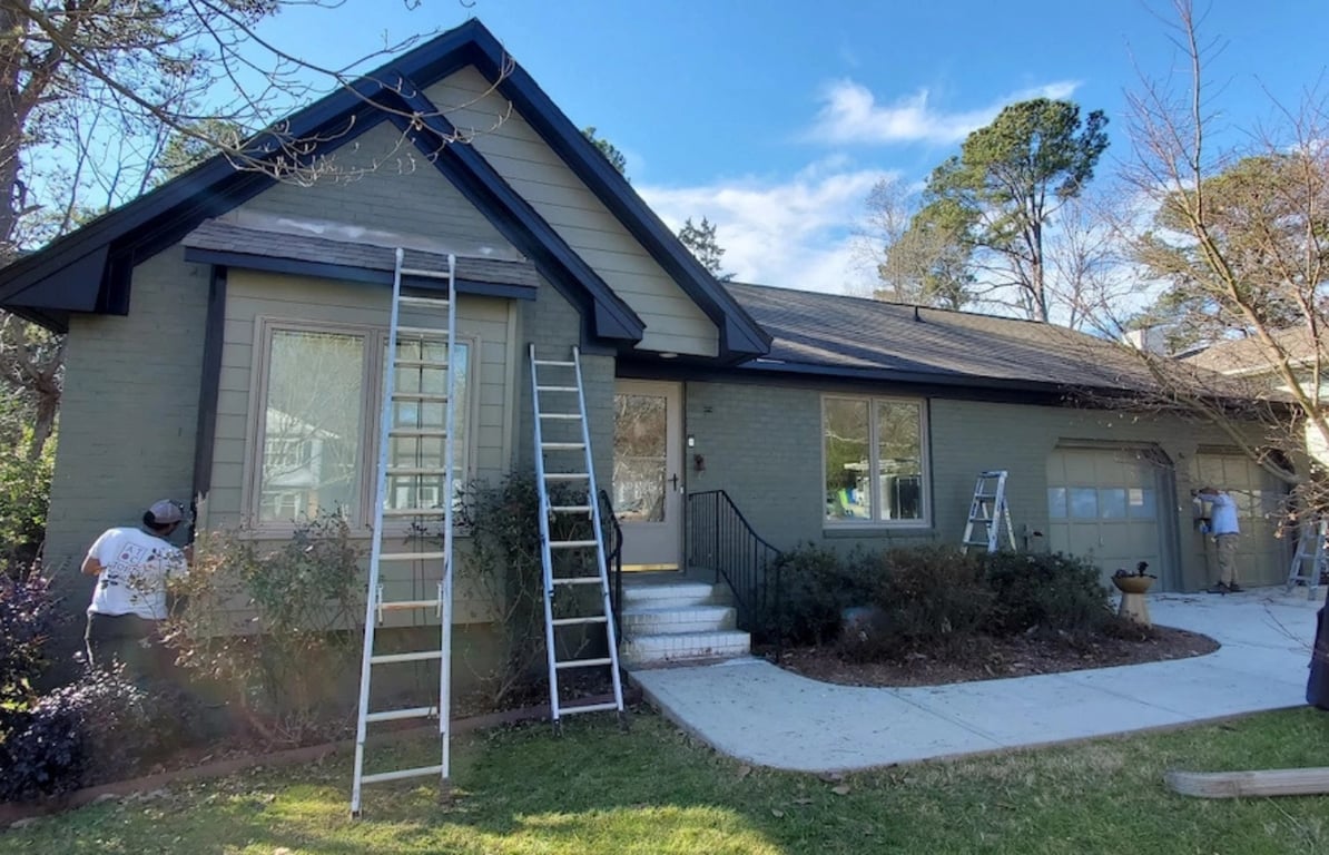 Green home exterior with black trim in the Lake Mount neighborhood of Raleigh, NC, fully repainted by A Touch of Color Painting & General Contracting using Sherwin-Williams Emerald Exterior paint.