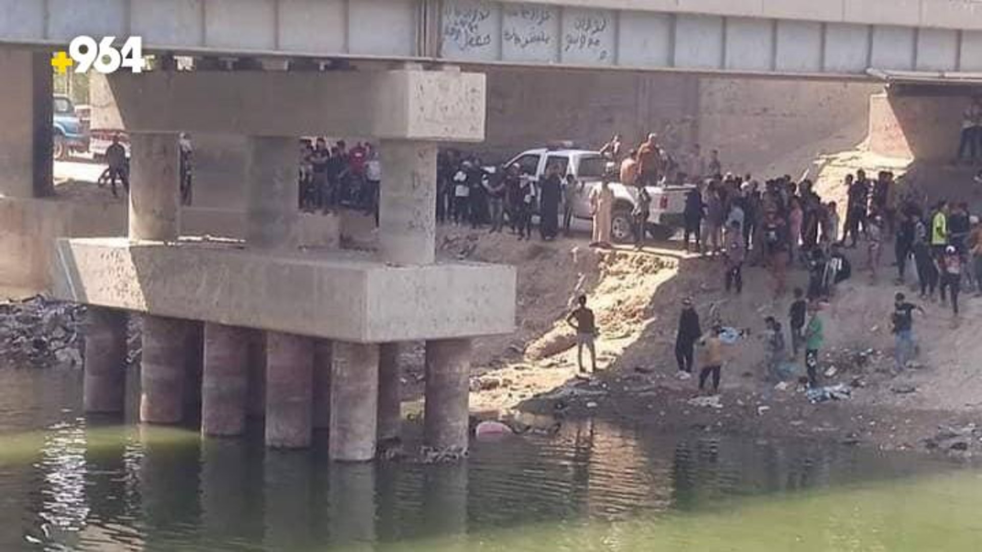 صورة: العشرات يتجمعون تحت جسر نهر الشامية بعد غرق زائر نزل للسباحة هرباً من الحر