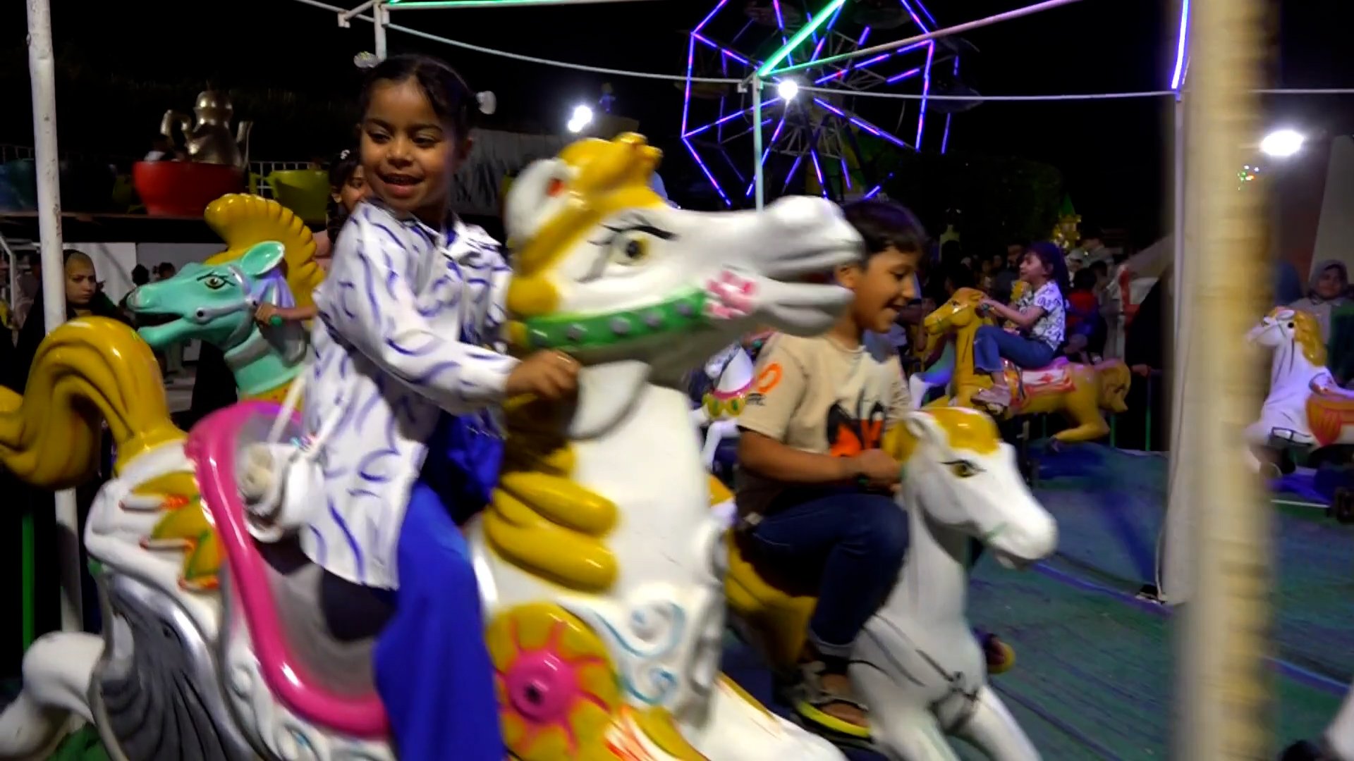 فيديو: أطفال سوق الشيوخ على الأحصنة الدوارة عند 