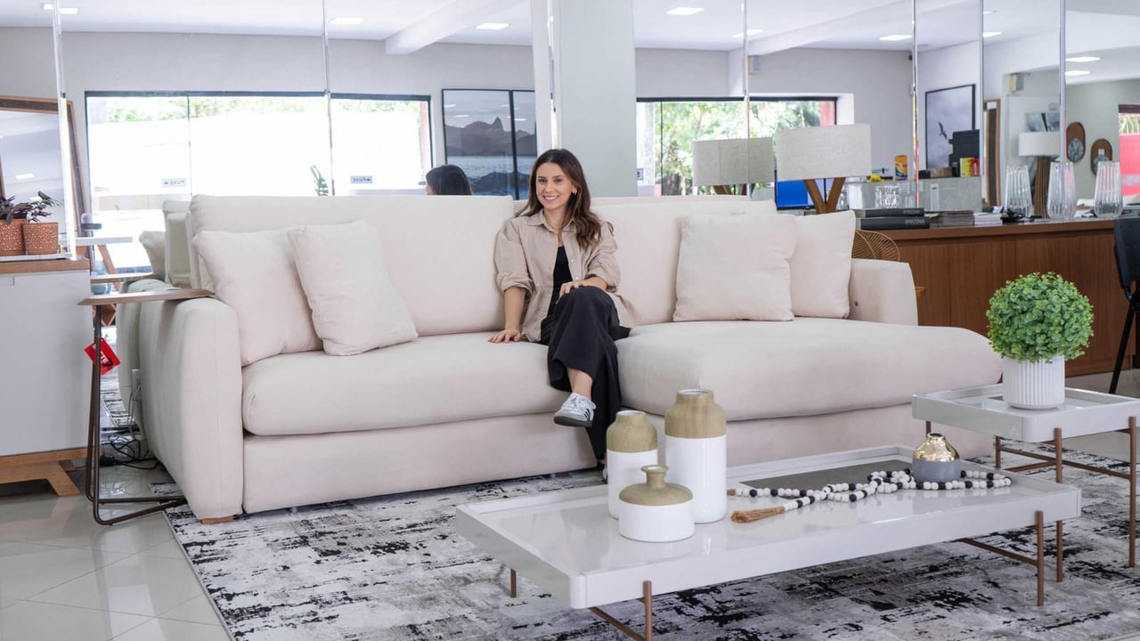 Sala de estar com sofá amplo, mesa de centro e iluminação natural — showroom Sette Móveis