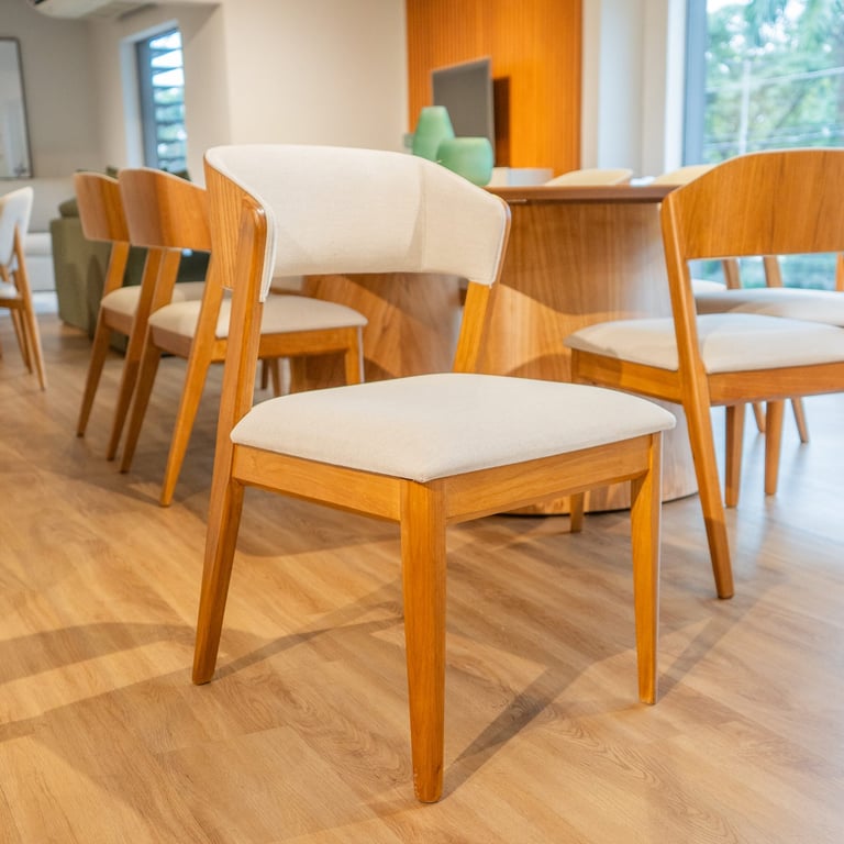Cadeira Garden em tauari com encosto curvo envolvente, interno estofado em tecido off-white e externo em madeira laminada, assento estofado