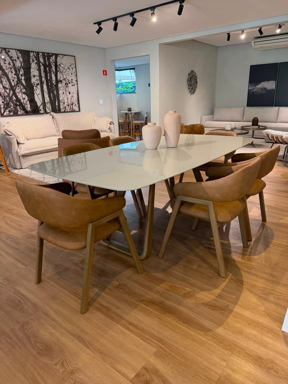 Mesa de jantar Zoe com pés em madeira maciça e cadeiras estofadas formato poltrona, vista em perspectiva