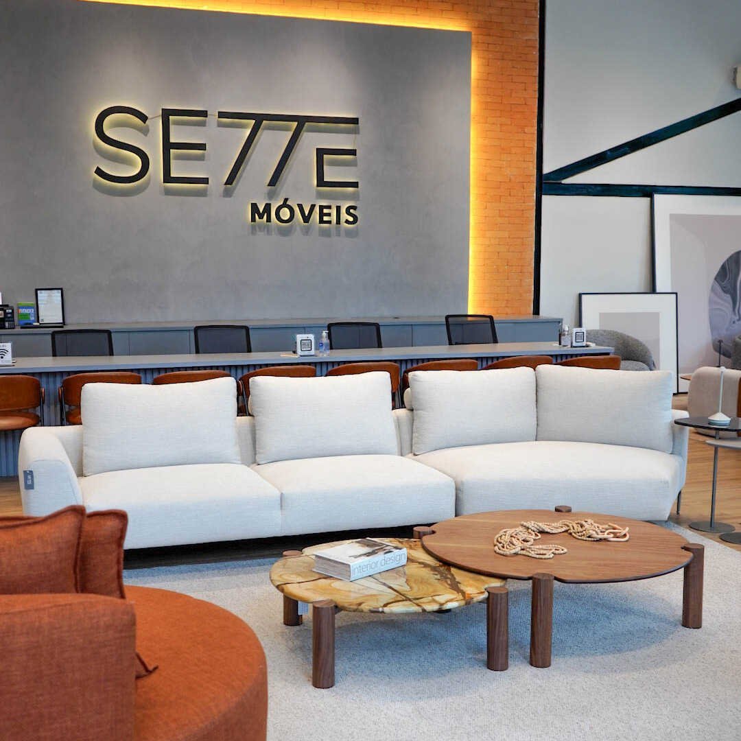 Sofá Alento modular off-white de linhas retas em showroom com parede de concreto