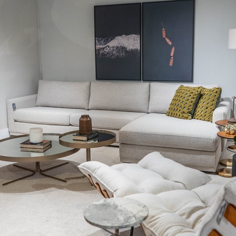 Sofá Dubai fixo em tecido cinza-claro com chaise à direita, almofadas soltas de encosto e duas almofadas decorativas em tricô verde-oliva
