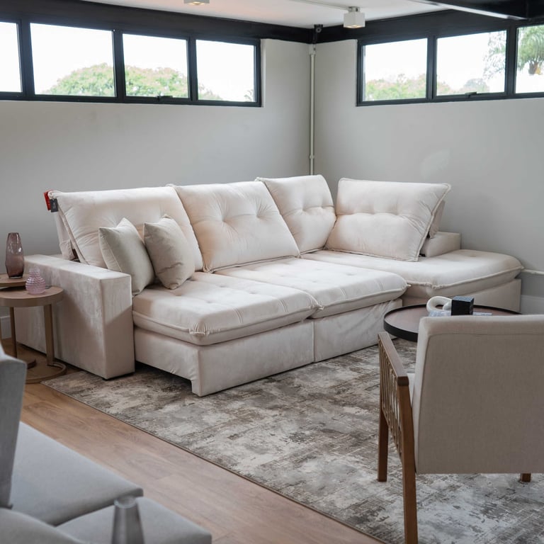 Sofá Retrátil Articulado Abel em L de tecido aveludado cru, com chaise e encosto tufado, em showroom