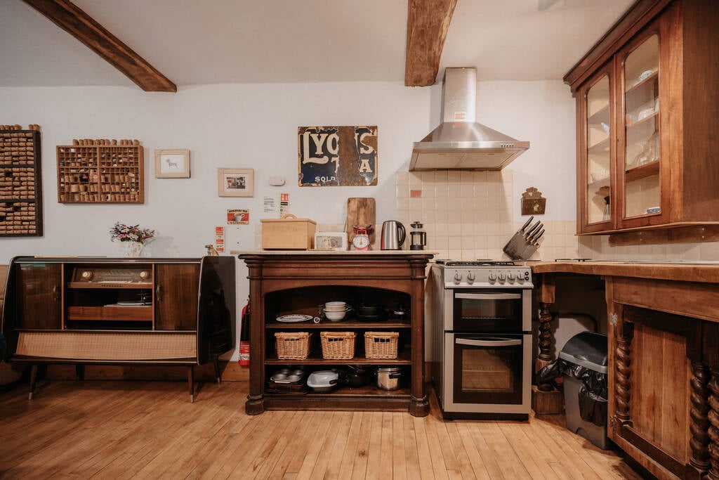Kitchen equipped with an oven, stove, toaster, kettle and cooking utensils, crockery and glassware