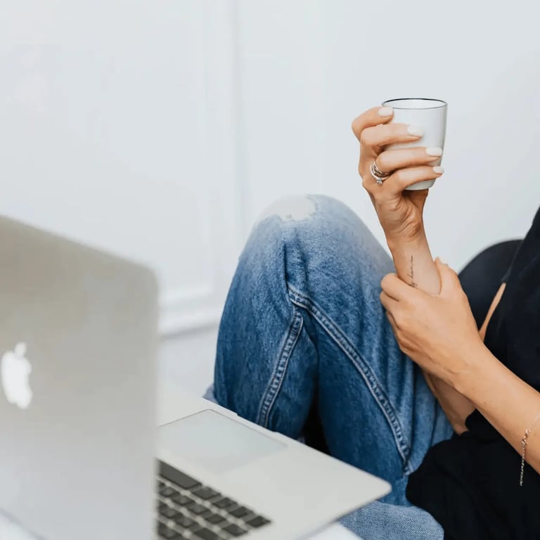 Person entspannt sich mit Laptop und Kaffee zu Hause