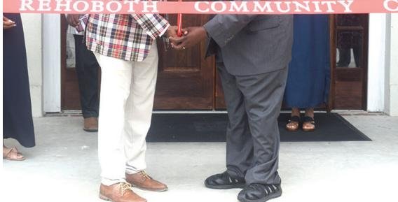 Rev. Ivory Thigpen (left) cuts the ribbon on the new Rehoboth Community Resource Center.