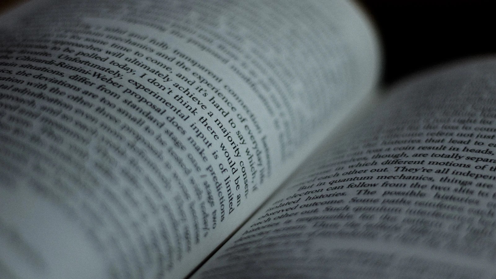 An open book with curved pages and a narrow band of text in focus.