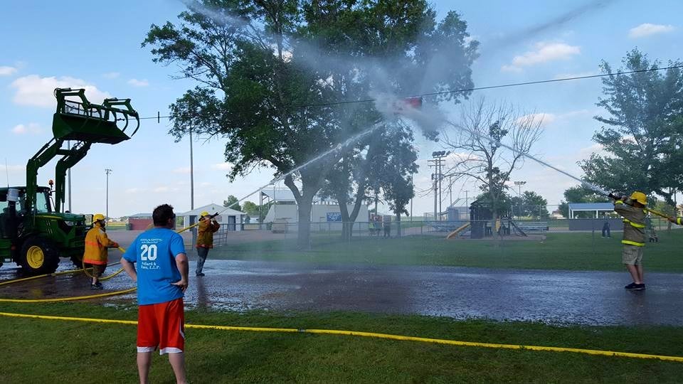 Two firefighters have a water fight.