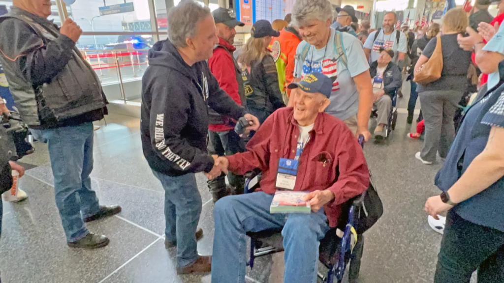 Retired Capt. Holmes and other veterans are greeted at the airport.