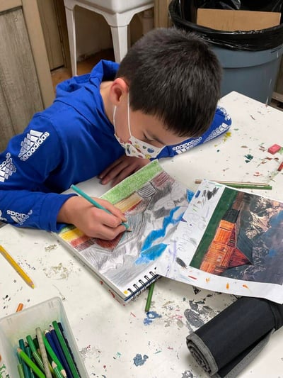 A young by wearing a blue sweatshirt participates in a kids class.