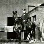 Ladderman Gilbert W. Jones riding a police horse at the rear of quarters, 941 Boylston Street, Back Bay, circa 1920.