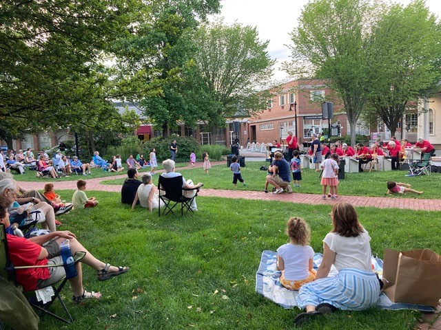A crowd gathers to listen to live music outside in Lexington, Massachusetts in the summer.