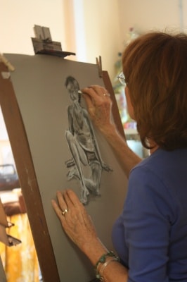 Older woman drawing with charcoal