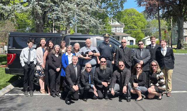 The family of fallen Billerica Police Officer Kenneth Collins stands with Billerica Police K9 KC, who is named in Officer Collins’ honor. K9 KC was able to visit the funeral of Officer Collins’ widow, Margie, who passed away last week at age 95. (Photo Courtesy Billerica Police Department)