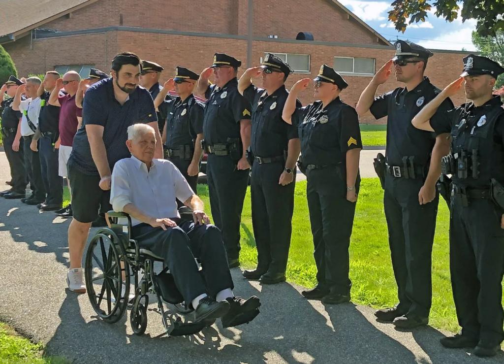 Billerica Police officers salute retired Capt. Paul Holmes, a World War II Veteran who after the war served for 37-years with the Billerica Police Department. Billerica Police drove Holmes to and from the airport this weekend as Honor Flight New England flew Holmes and other veterans to Washington DC to tour the nation’s monuments.
