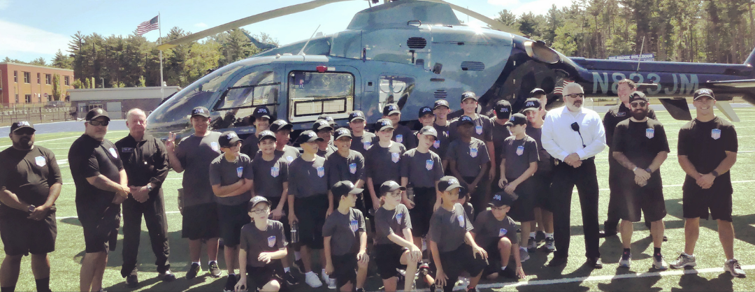 Junior Police Academy participants standing in front of a helicopter