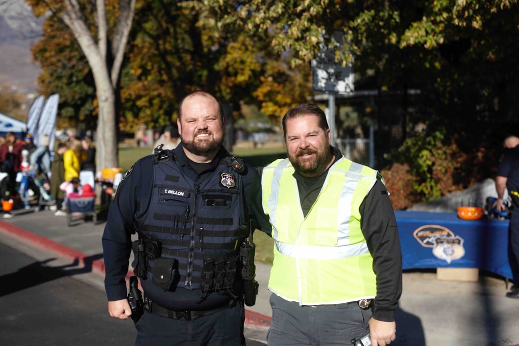 A male police officer and a male crossing gaurd pose for a photo.