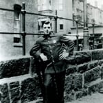 Ladderman Gilbert W. Jones, in uniform, on a bridge adjacent to quarters at 941 Boylston Street, circa 1920.