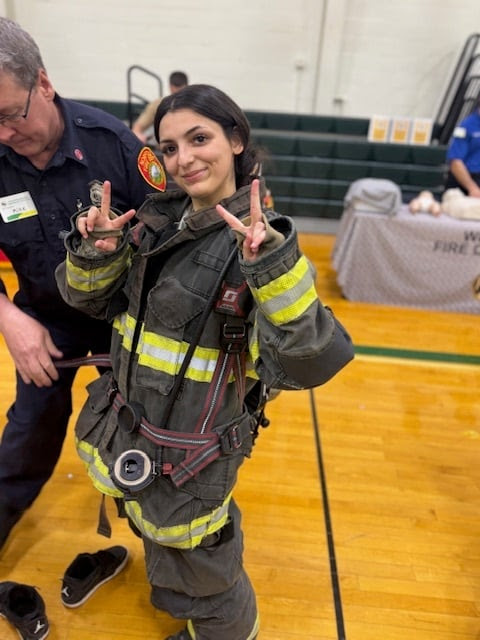 A King Philip Regional High School student tries on turnout gear from the Norfolk Fire Department during the Career Fair.