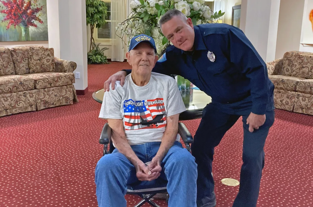 Retired Lt. Commander Troy Opland, at right, poses with retired Capt. Paul Holmes before Holmes was driven to the airport to participate in a flight to Washington, DC with Honor Flight New England.