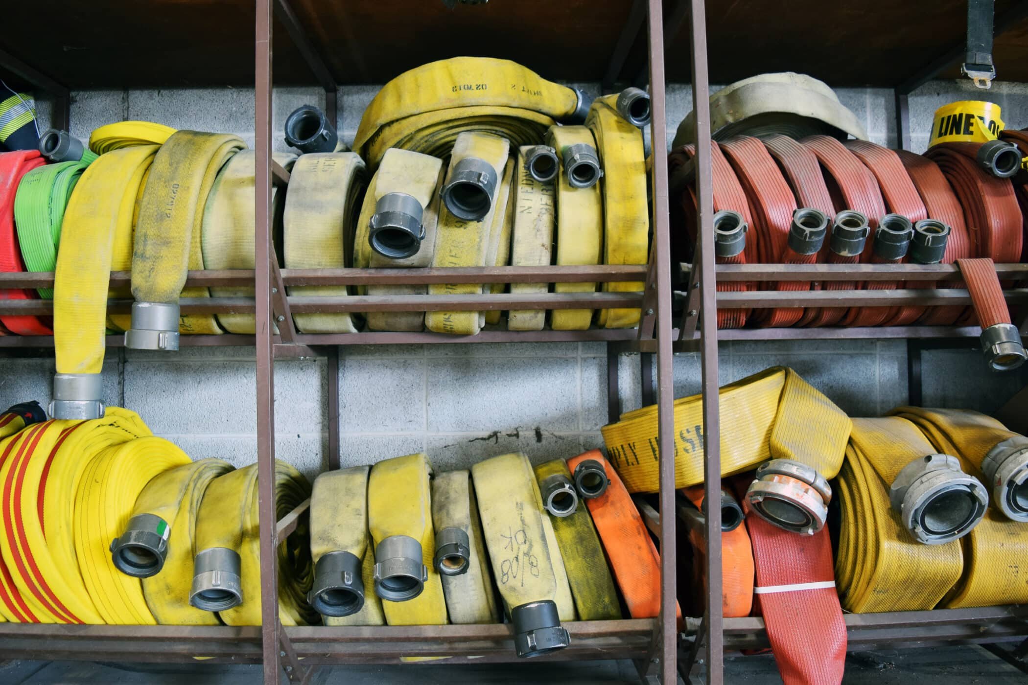 Fire department hoses rolled up on a shelf.