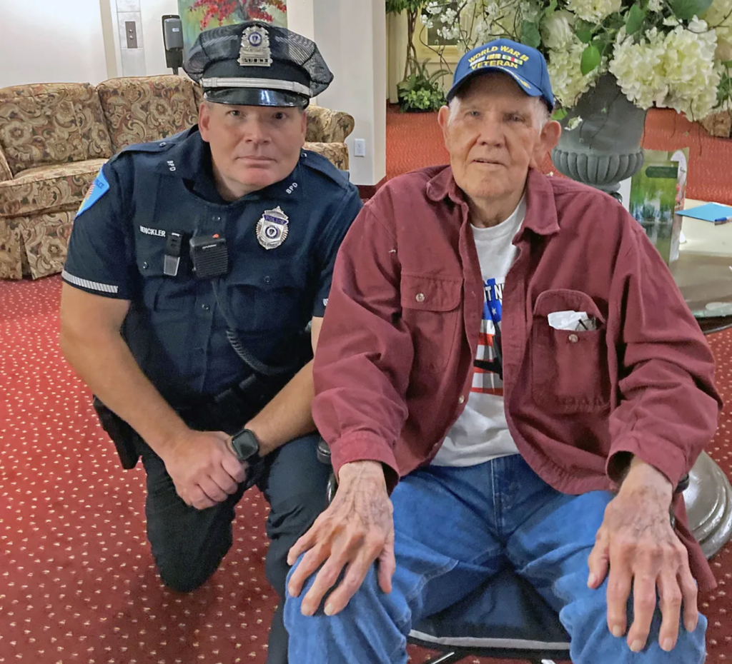 Officer Mike Henckler poses with retired Capt. Holmes before driving him to the airport on Sunday morning.