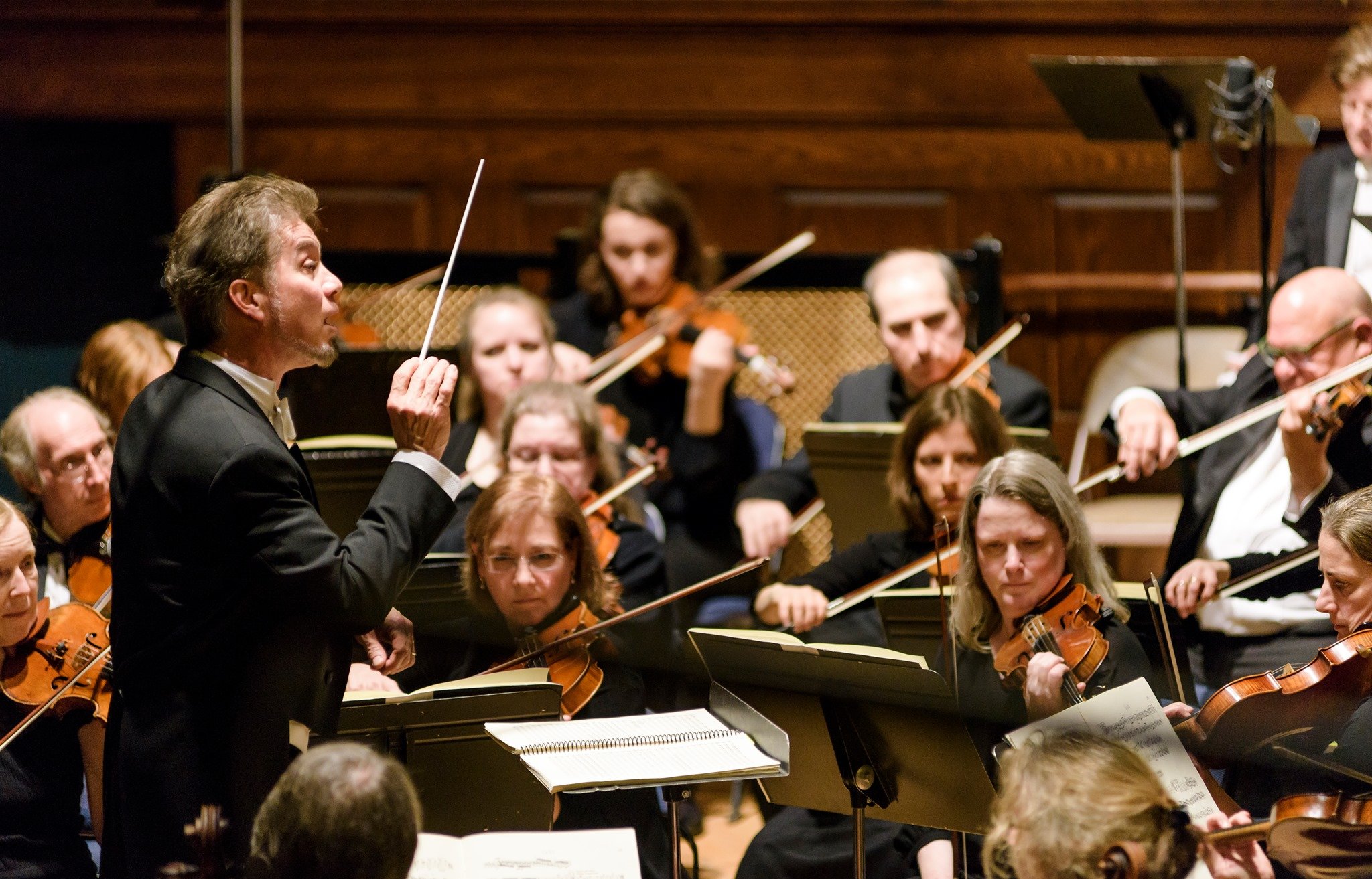 Male conductor leads the Lexington Symphony in song.