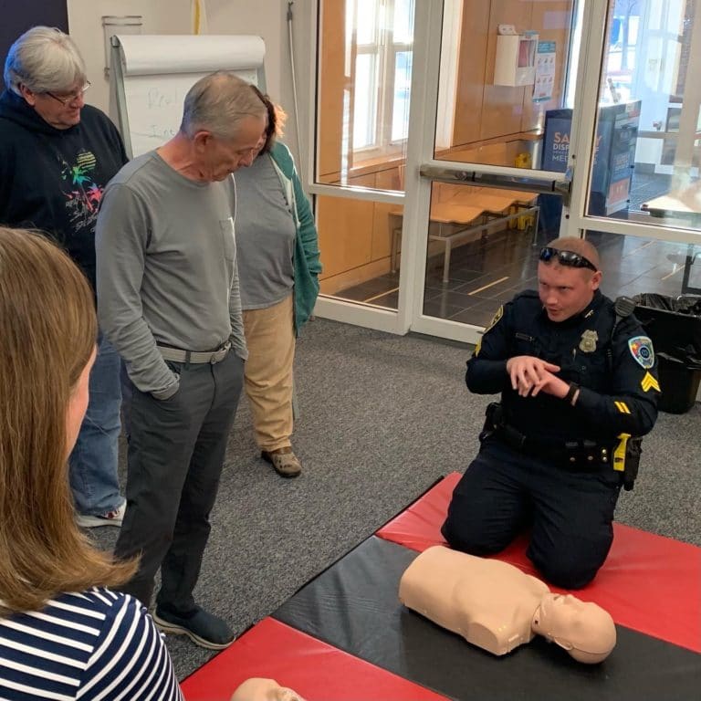 Wilmington Police Officer demonstrates CPR during a training for community members.