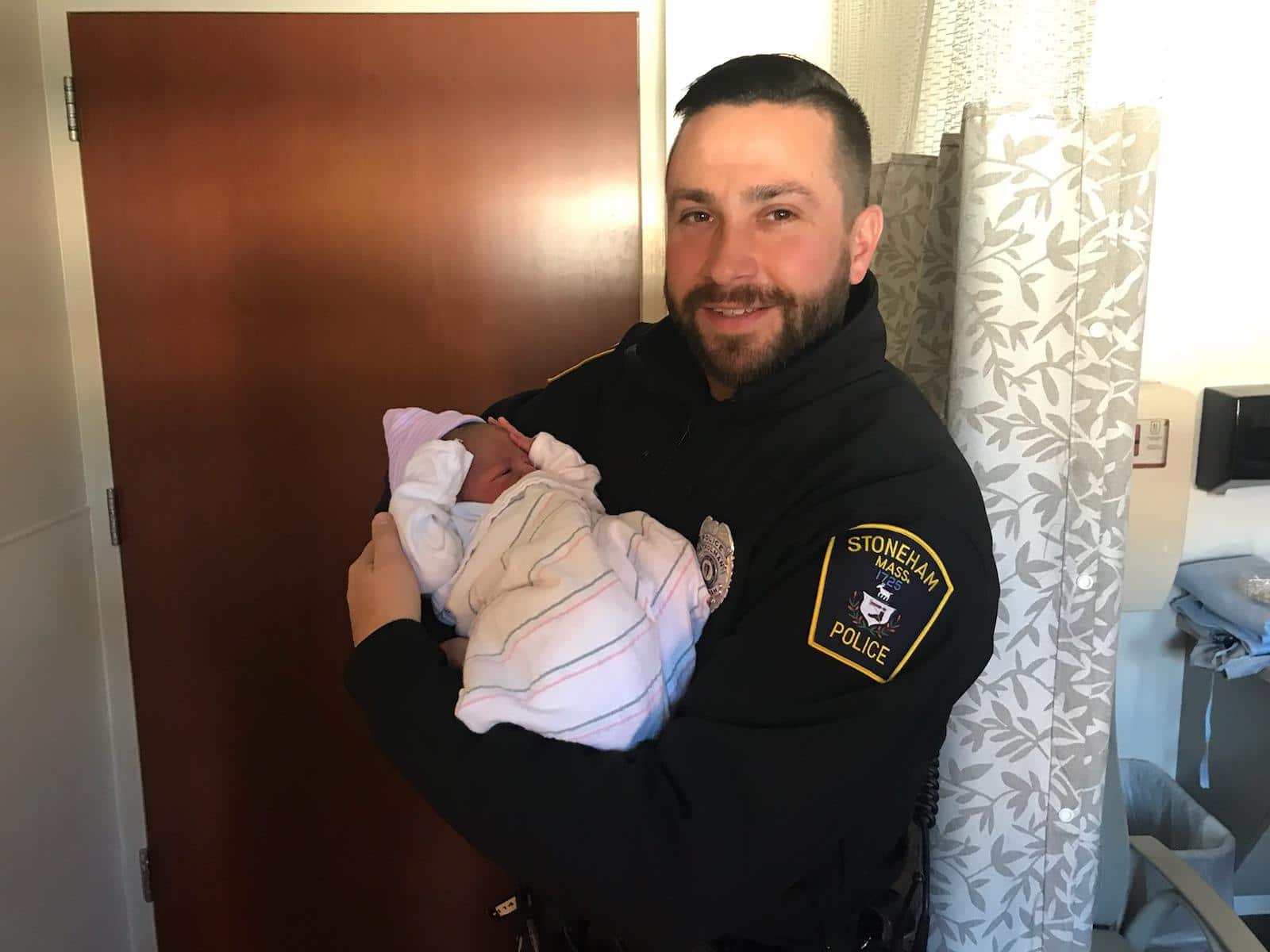 Stoneham Police Officer Michael Colotti holding the baby he helped deliver on Thanksgiving (Stoneham Police/Courtesy Photo)