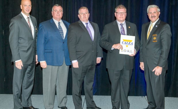 Danvers Police Captain/Accreditation Manager Patrick Ambrose (left), Lieutenant James Lovell (middle), and Chief Neil Ouellette (second from right) receive the CALEA Re-Accreditation Award from CALEA officials. Pictured are Executive Director W. Craig Hartley Jr. (Second from left) and Commission Chairman J. Grayson Robinson (right). (Courtesy of the Danvers Police Department)