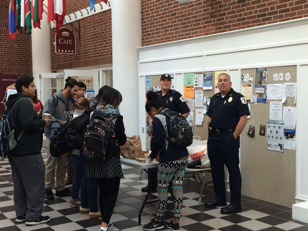 Bedford Police Officer Craig Naylor (left in uniform) and Chief Robert Bongiorno greet students during last year's Coffee with a Cop event at Middlesex Community College.