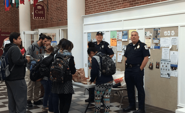 Bedford Police Officer Craig Naylor (left in uniform) and Chief Robert Bongiorno greet students during last year's Coffee with a Cop event at Middlesex Community College.