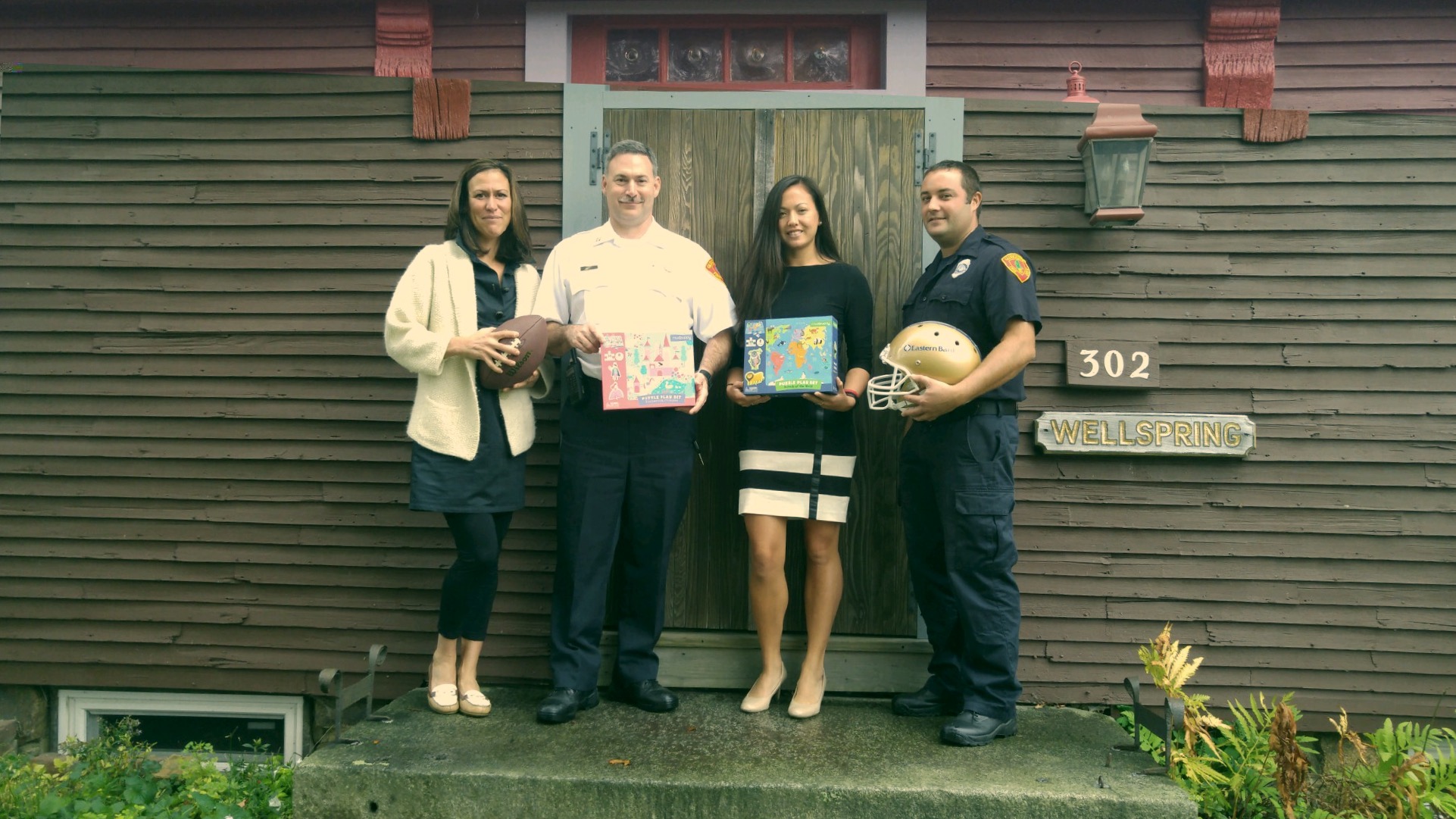 The Gloucester Fire Department will hold a toy drive later this month to benefit the Wellspring House's holiday store. Chief Eric Smith, left, and Firefighter Dean DeCoste, right, met with Wellspring House staff at their holiday store kickoff meeting earlier this year. (Courtesy Photo)