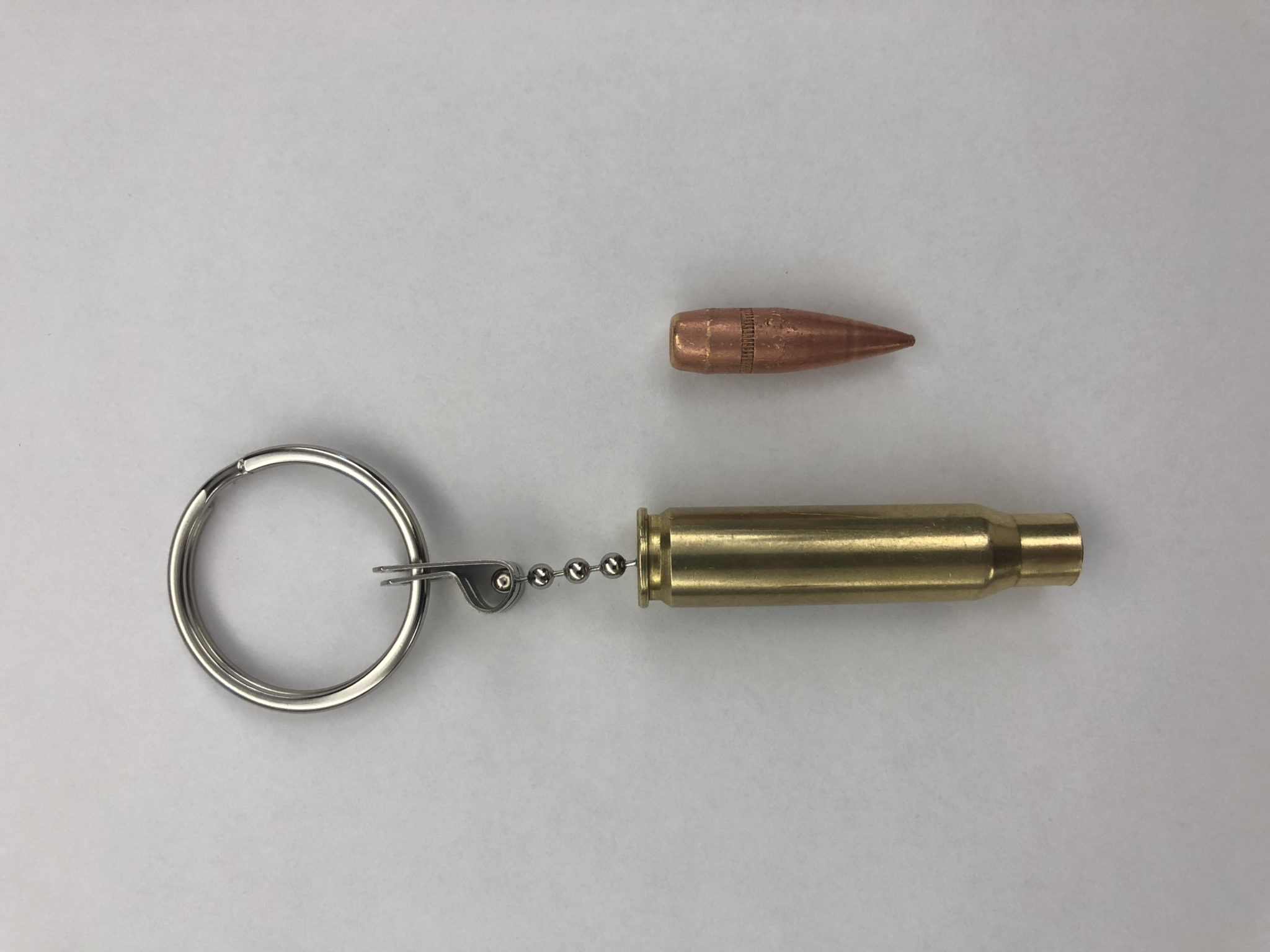 The real slug (top) was attached to an empty brass casing and made into a keychain that was owned by a student at the Byam Elementary School in Chelmsford. Officials have discussed the appropriateness of such a keychain with the student after the slug broke off on Wednesday and was found on a sidewalk outside the school by a custodian. (Chelmsford Police Department/Courtesy Photo)