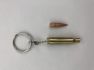 The real slug (top) was attached to an empty brass casing and made into a keychain that was owned by a student at the Byam Elementary School in Chelmsford. Officials have discussed the appropriateness of such a keychain with the student after the slug broke off on Wednesday and was found on a sidewalk outside the school by a custodian. (Chelmsford Police Department/Courtesy Photo)