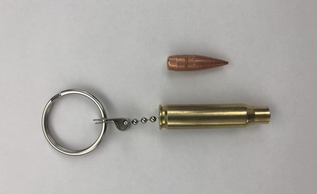 The real slug (top) was attached to an empty brass casing and made into a keychain that was owned by a student at the Byam Elementary School in Chelmsford. Officials have discussed the appropriateness of such a keychain with the student after the slug broke off on Wednesday and was found on a sidewalk outside the school by a custodian. (Chelmsford Police Department/Courtesy Photo)