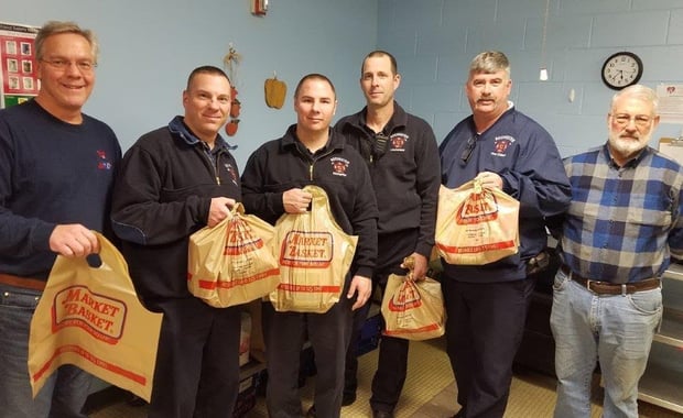 Members of the Rochester Fire Department pose with bags of food that will go to city children to help ensure that they have healthy meals to eat during the weekend days when they are away from school. Pictured left-to-right: Dave Bogan, Jason Laferte, Matthew Parker, Mike George, Chief Mark Klose, Former Mayor John Larochelle (Courtesy photo)