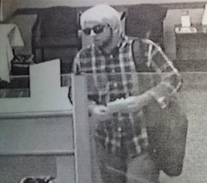 The Bedford Police Department is looking for a man who allegedly robbed Brookline Bank this morning. He is described as a white male with a brown beard, plaid long-sleeved shirt, dark sneakers, black backpack, sunglasses and possibly wearing a blonde wig. (Courtesy Photo).