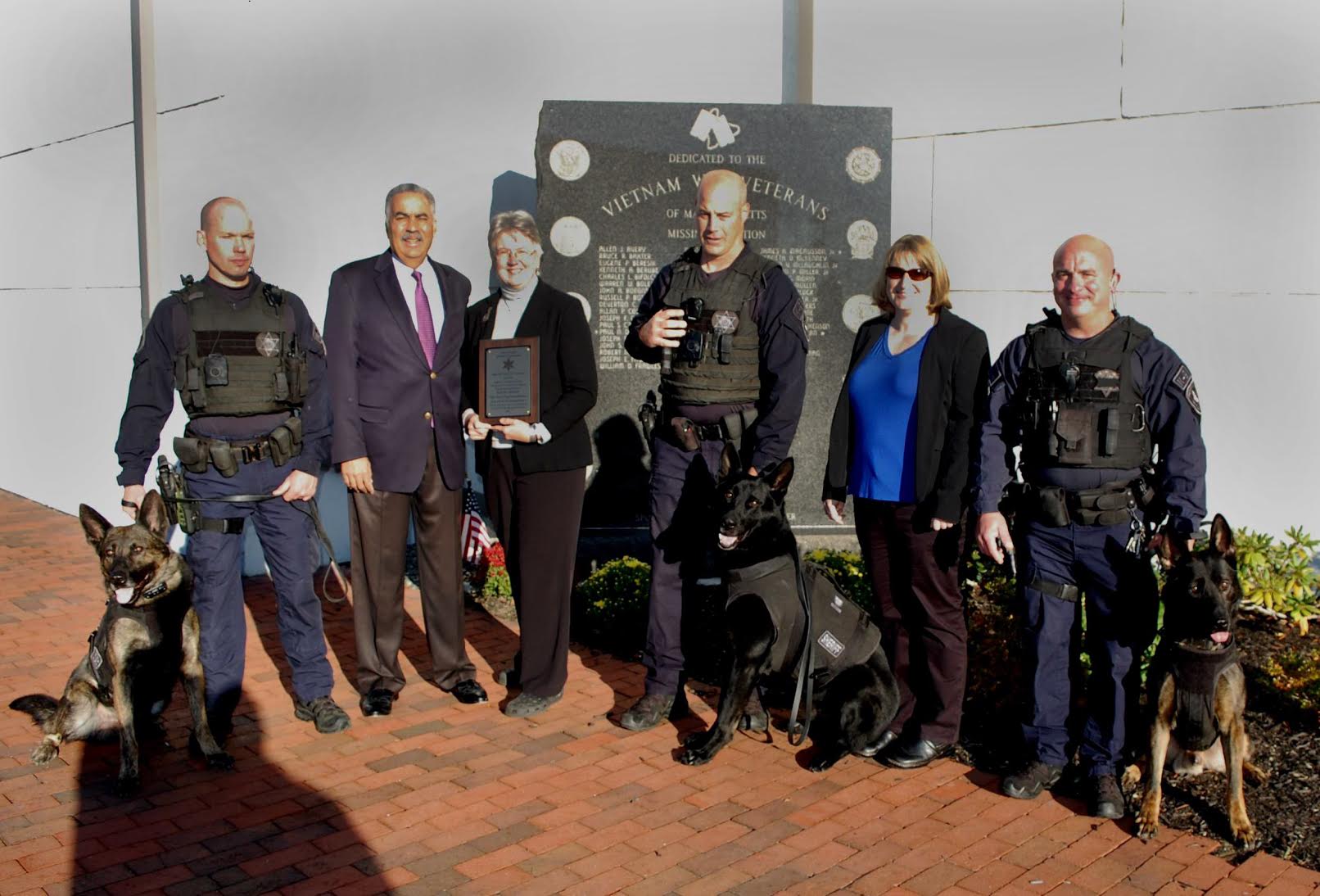 Sheriff Frank Cousins presented a thank you plaque to Kathy Hinds, President of Vest-a-Dog, for the organization's continued support over the years. Left to right: Sgt. Stephen Pomerleau and K-9 Dakota, Sheriff Cousins, Kathy Hinds, Lt. John Pickles and K-9 Ivan, Michele Perrine, Vest-a-Dog board member and lead volunteer, and Sgt. John Zaccari and K-9 Tyson. (Courtesy Photo)