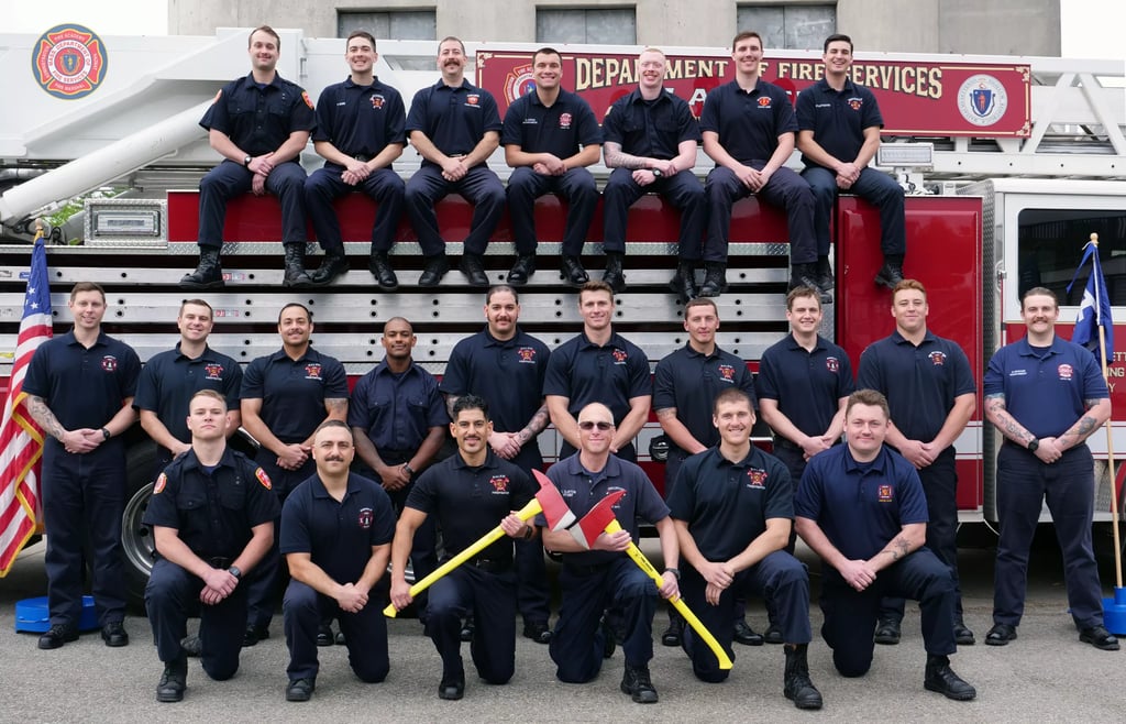 Mass Firefighters Academy graduates in front of fire truck