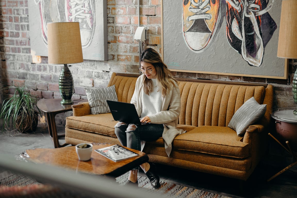 woman sitting at desk with laptop and coffee