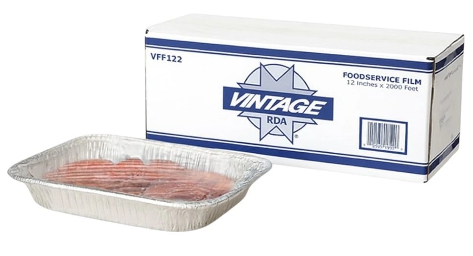 Tray filled with sliced food is tightly covered with clear 12 x 2000' heavy duty plastic wrap for food